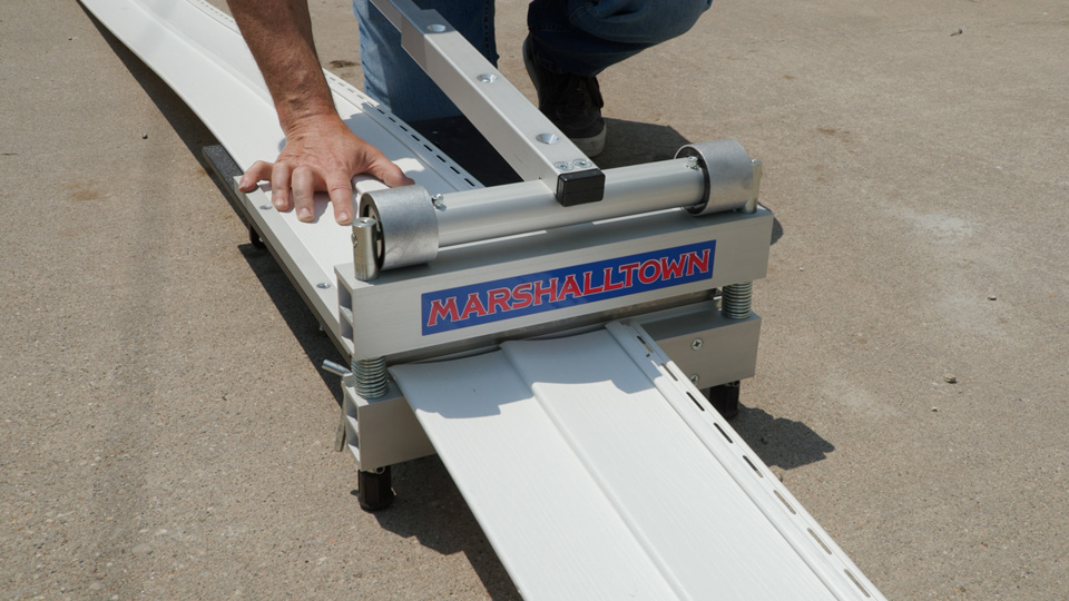 using the siding cutter to cut the new panel to the right length